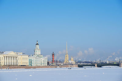 Buildings in city against blue sky