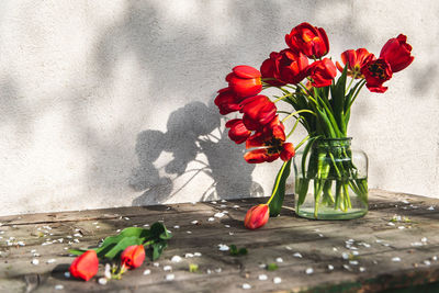 Close-up of red tulips in glads vase on table