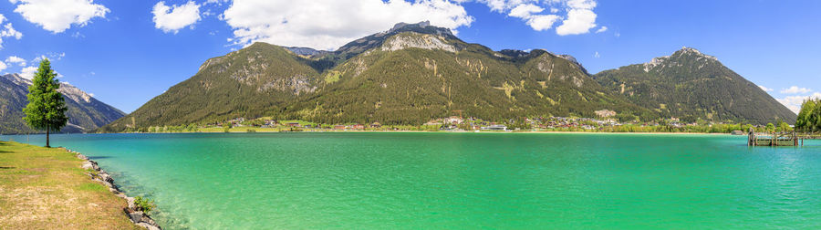 Panoramic view of lake and mountains against blue sky