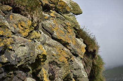 Close-up of rocks on rock against sky