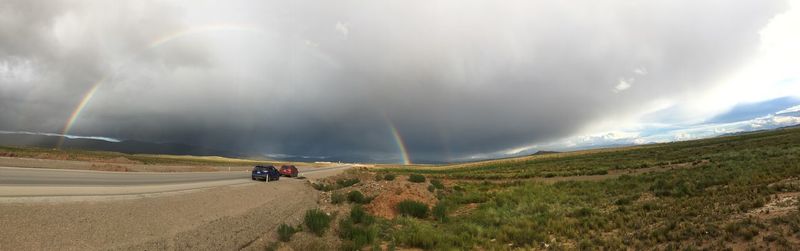 Car on road against rainbow in sky