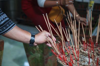 Cropped hand holding incense in temple