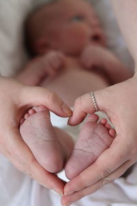 Cropped hands of woman holding baby legs