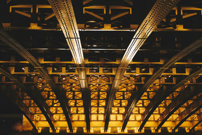 Low angle view of illuminated bridge at night