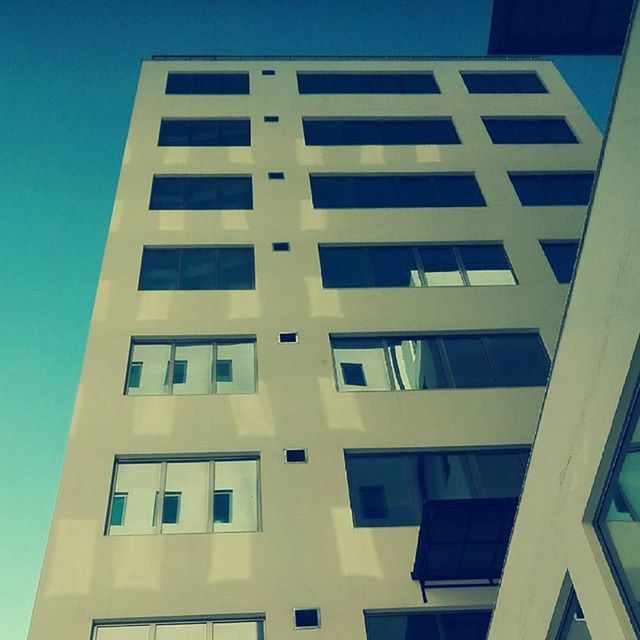 architecture, building exterior, built structure, low angle view, window, building, city, modern, office building, clear sky, tall - high, sky, glass - material, residential building, apartment, day, skyscraper, outdoors, residential structure, reflection