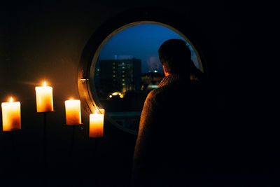 Rear view of woman in illuminated room