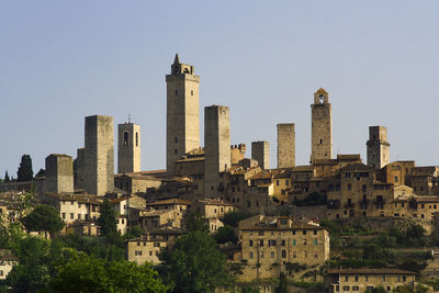 Buildings in city against clear sky