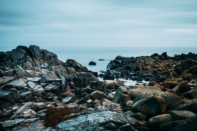 Rocks by sea against sky
