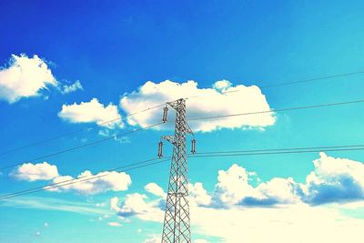 Low angle view of electricity pylon against cloudy sky