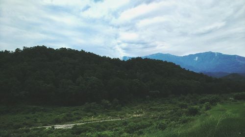 Scenic view of mountains against cloudy sky