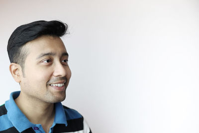 Portrait of smiling young man against white background