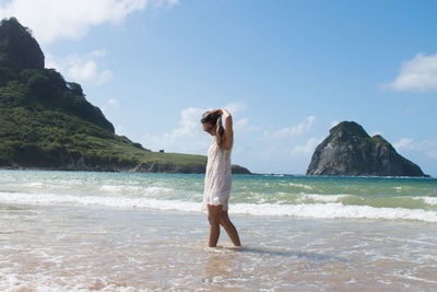 Full length of man standing on beach against sky