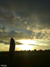 Silhouette field against sky during sunset