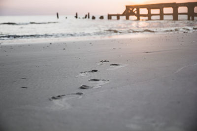 Surface level of beach against sky during sunset