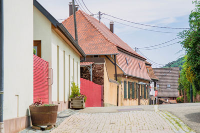 Street amidst houses and buildings against sky