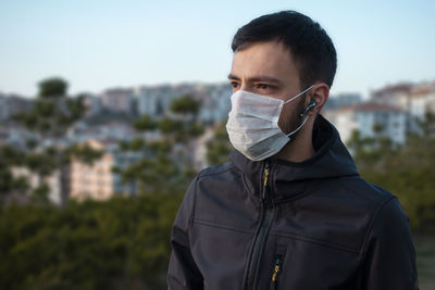 Young man wearing mask standing outdoors