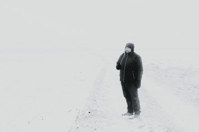 Man walking on snow covered land