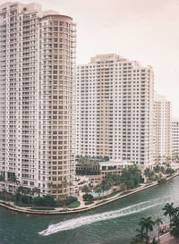 Cityscape by sea against sky