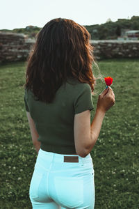 Rear view of woman standing on field