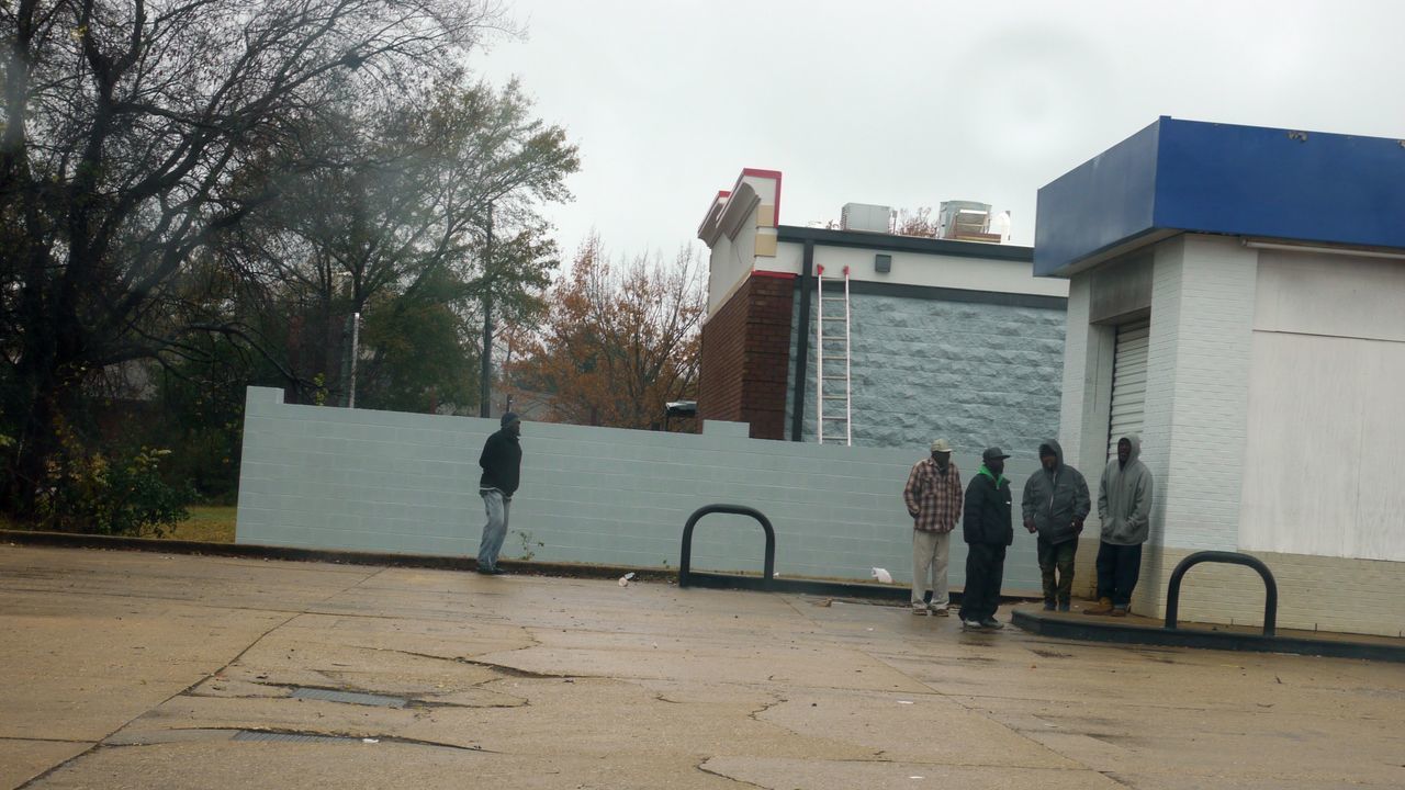 PEOPLE WALKING ON STREET IN FRONT OF BUILDINGS