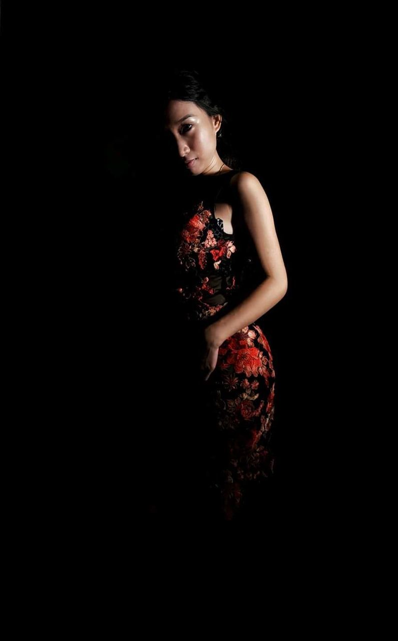 black background, studio shot, one person, indoors, red, fashion, young adult, adult, dress, clothing, portrait, looking at camera, standing, hairstyle, women, full length, copy space, front view, three quarter length, beautiful woman, contemplation