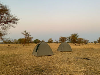 Tent on field against clear sky during sunset