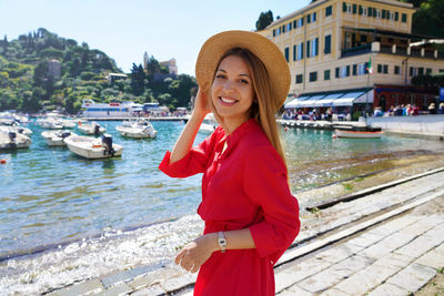 Stylish woman in red dress and hat in portofino, liguria, italy
