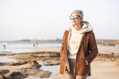 Portrait of young woman standing at beach