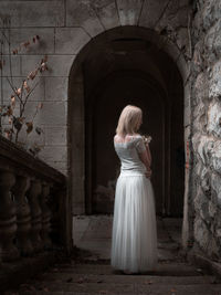 Rear view of young woman standing in historic building