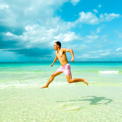 Full length of shirtless boy on beach