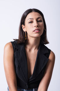 Beautiful young girl posing in a studio with a grey backdrop