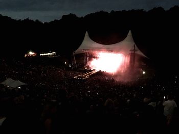 Crowd at music concert against sky at night