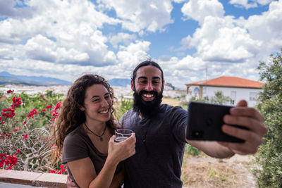 Portrait of smiling young woman using mobile phone