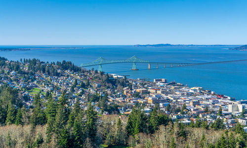 High angle view of city by sea against clear sky