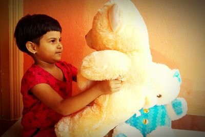 Cute boy holding toy at home