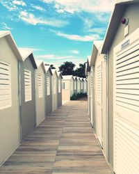 View of footpath amidst buildings against sky