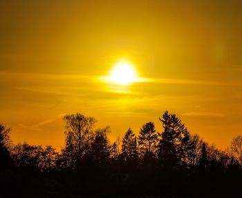 Silhouette trees against romantic sky at sunset