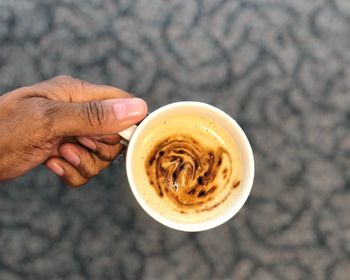 High angle view of hand holding coffee cup