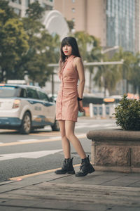 Portrait of young woman standing on road