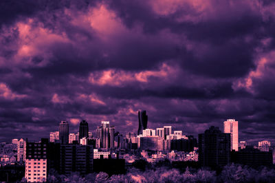 Buildings against dramatic sky during sunset