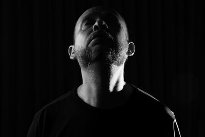 Portrait of a bearded man wearing eyeglasses against a black background. salvador, bahia, brazil.