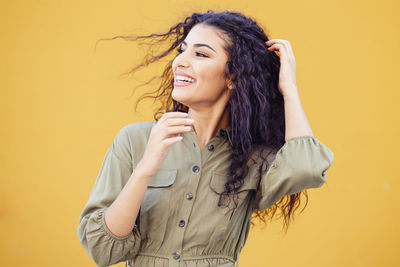 Beautiful young woman against yellow background