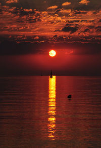 Scenic view of sea against cloudy sky during sunset