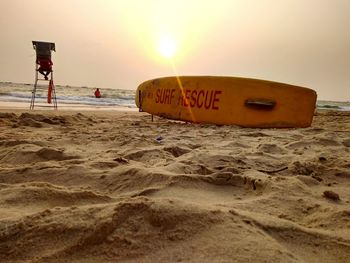 Lifeguard hut on beach against sky during sunset