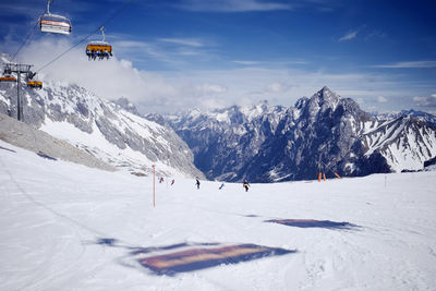 Ski lifts going above piste. the shadow of chairlifts reflected on the icy ground.