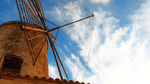 Low angle view of traditional windmill against sky