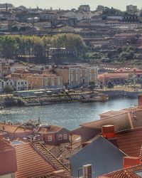 Houses by river in town against sky