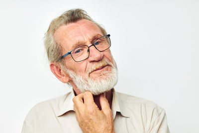 Portrait of young man wearing eyeglasses against white background