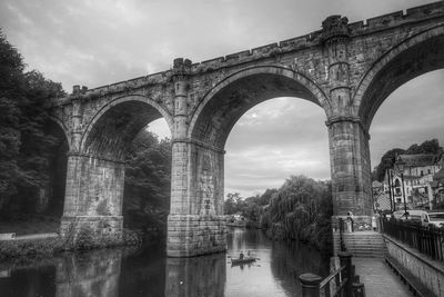 Arch bridge over river against sky