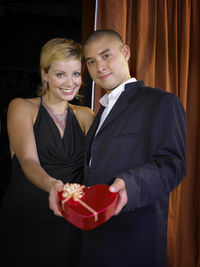 Portrait of smiling couple with gift standing in ceremony